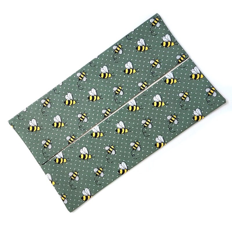 Soft pouch sewn from cotton fabric with bees on green background pattern to store facial tissues