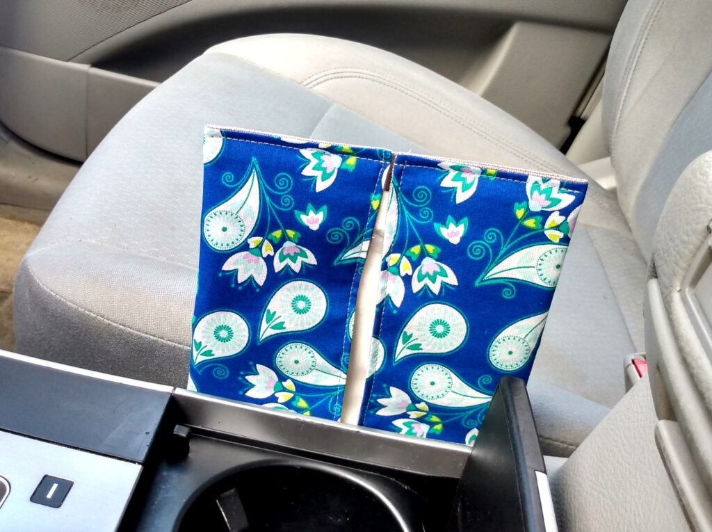a flat pouch with facial tissues placed between passenger seat and a console