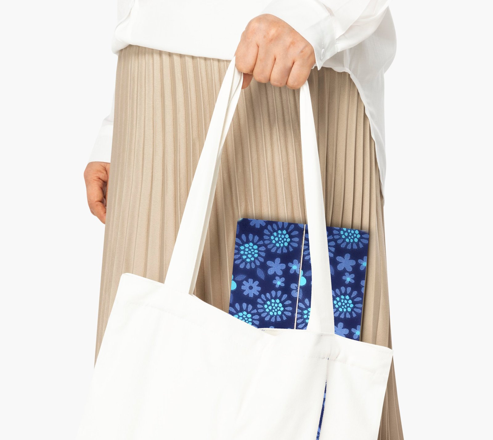 a woman's hand holding a white tote bag