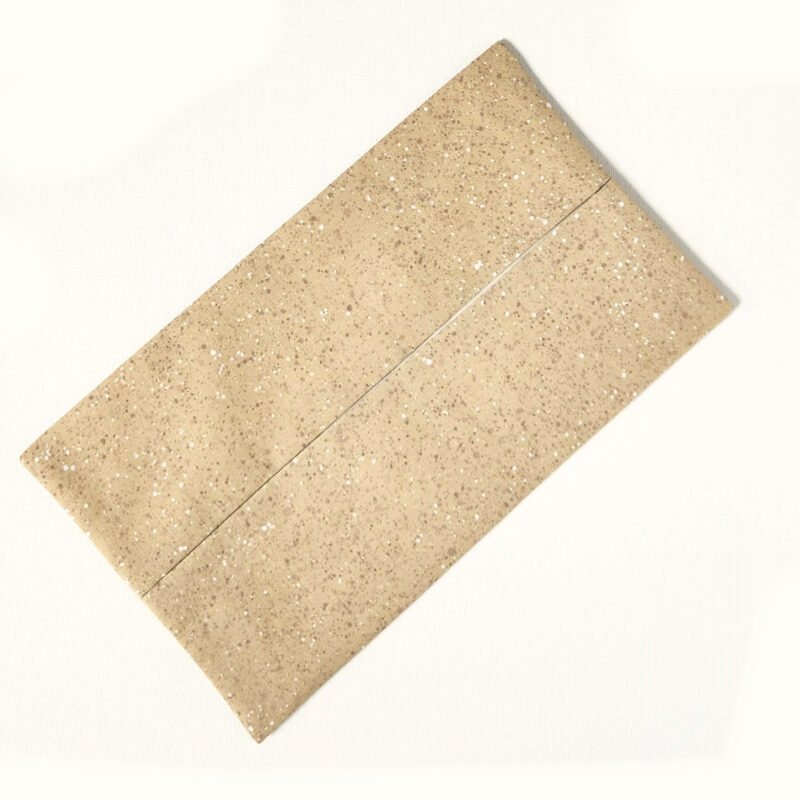 large flat pouch made from cotton fabric in speckled pattern with light beige and muted brown hues